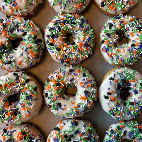 A close-up overhead view of Joe Donut's white-frosted donuts with Halloween sprinkles.